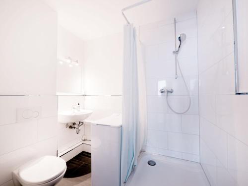uma casa de banho com um WC, um chuveiro e um lavatório. em Work & stay in Ahrensburg em Ahrensburg