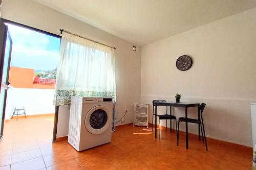 a living room with a washing machine and a table at Habitación privada Dorive con baño privado in San Andrés