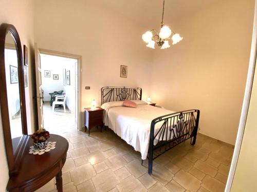a bedroom with a bed and a table and a chair at Casa vacanza Lalla in Santa Caterina di Nardò