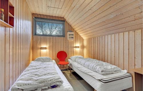 ein Krankenhauszimmer mit 2 Betten und einem roten Stuhl in der Unterkunft Amazing Home In Fan With Wifi in Sønderho