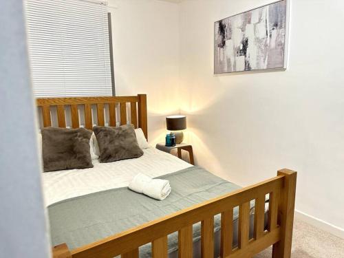 - une chambre avec un lit en bois et un oreiller dans l'établissement Luxury 3 Bed Home In London, à Londres