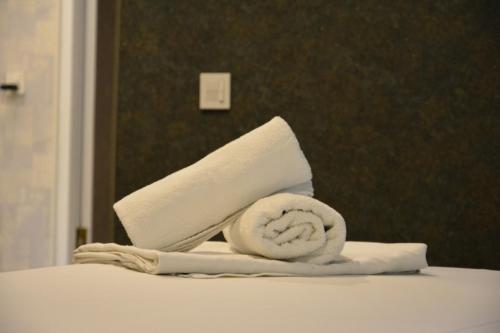 a roll of toilet paper and a roll of towels on a bed at Perron Hotel Baku in Baku