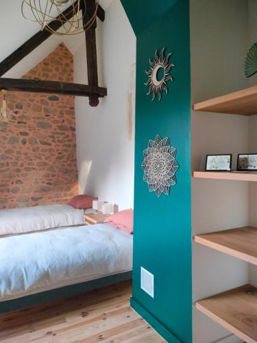 a bedroom with a bed and a brick wall at Gîte Au gré du vent - 12 personnes - Calme, nature et confort in La Goutelle