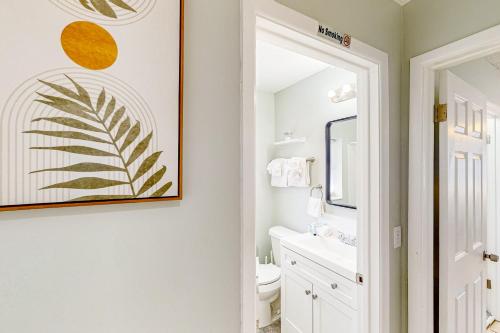 a bathroom with a white toilet and a picture on the wall at Beach Life in Panama City Beach