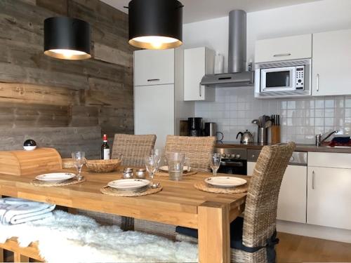 una cucina con tavolo in legno, sedie e un angolo cottura. di Steinadler Seekareck FL - Skiing Holiday in Obertauern a Obertauern
