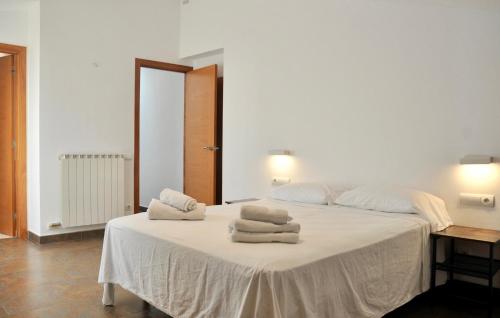 een slaapkamer met een wit bed en handdoeken bij Residential Tourist Apartments in Caldes d'Estrac