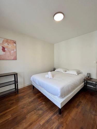 une chambre avec un lit blanc et un parquet dans l'établissement Le Grand Mondi, à Mareuil-sur-Cher