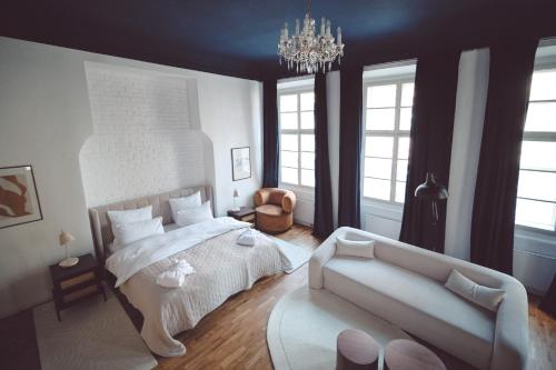 a bedroom with a large bed and a couch at Domus Balthasar Boutique Hotel in Prague