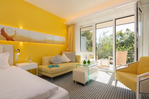 a hotel room with a bed and a couch at Sonnenhof Hotel & Spa in Lautenbach