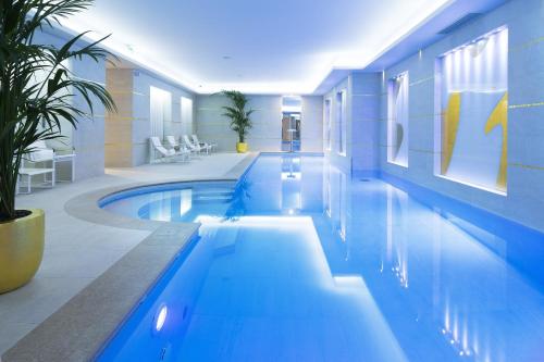 a swimming pool in a building with a blue at Le Burgundy Paris in Paris