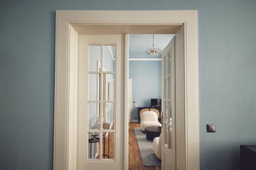 a door leading to a living room with blue walls at Domus Balthasar Boutique Hotel in Prague