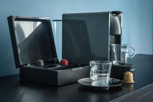 a kitchen sink with a blender and a glass on a table at Domus Balthasar Boutique Hotel in Prague