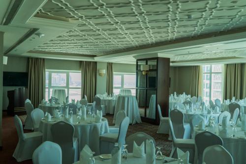 a banquet room with white tables and chairs at Ramada by Wyndham Manama City Centre in Manama