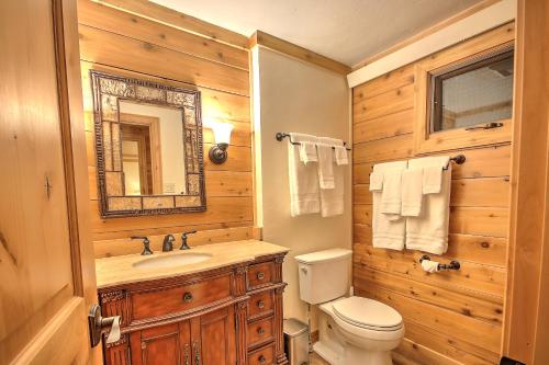 y baño con aseo, lavabo y espejo. en Premier Yellowstone River Home en Gardiner
