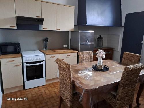 - une cuisine avec une table, des chaises et une cuisinière dans l'établissement Villa Thomas, à Arcachon