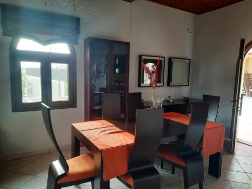 a dining room with a wooden table and chairs at Marathon VS LUXURY VILLA in Grammatiko