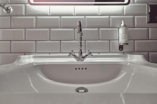 a white sink with a faucet in a bathroom at Domus Balthasar Boutique Hotel in Prague