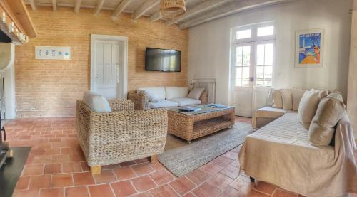 un salon avec un canapé, des chaises et une télévision dans l'établissement Charmante Maison dans Les Landes x 10 avec piscine et salle d escalade, à Lue