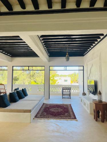 a living room with a couch and some windows at Milimani Villa-Fully airconditioned Villa in Shela