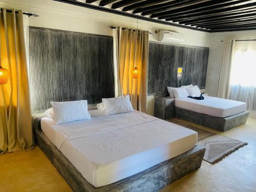 two beds in a bedroom with yellow curtains at Milimani Villa-Fully airconditioned Villa in Shela
