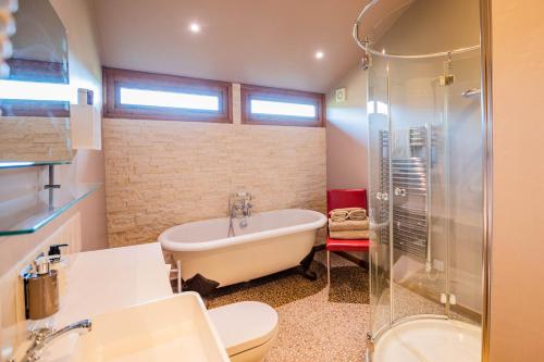 a bathroom with a tub and a toilet and a sink at Three Choirs Vineyards in Newent