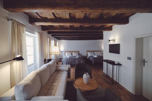 a living room with a couch and a bed at Domus Balthasar Boutique Hotel in Prague