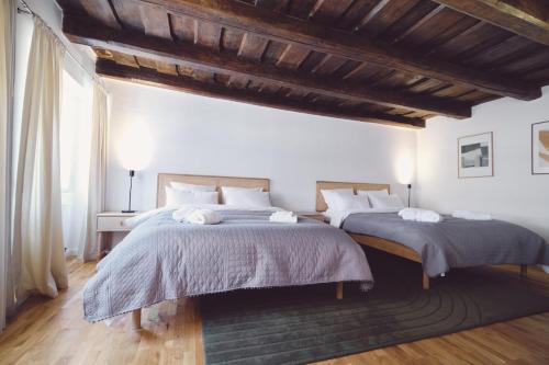 a bedroom with two beds and a large window at Domus Balthasar Boutique Hotel in Prague