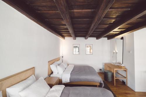 a bedroom with two beds and a couch at Domus Balthasar Boutique Hotel in Prague