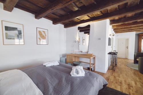 a bedroom with a bed with towels on it at Domus Balthasar Boutique Hotel in Prague