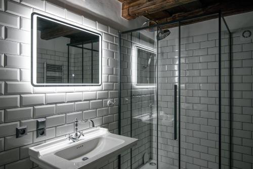 bagno bianco con lavandino e specchio di Domus Balthasar Boutique Hotel a Praga