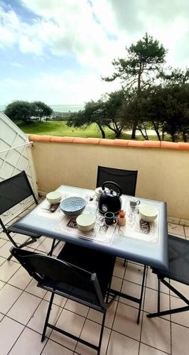 une table et des chaises sur un balcon avec une théière dessus dans l'établissement 