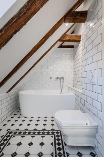 a bathroom with a white tub and a toilet at Domus Balthasar Boutique Hotel in Prague
