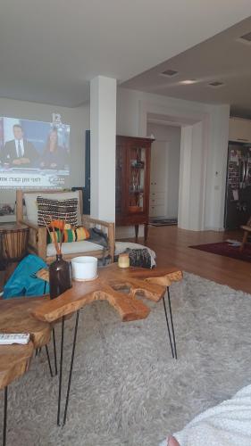 a living room with a table with logs on it at שרון על המים in Herzliyya B