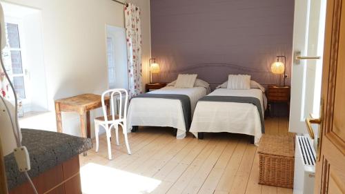 a bedroom with two beds and a table and a chair at Au Coq Bleu in Mareugheol