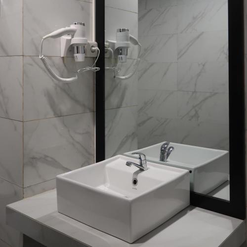 a bathroom with a white sink and a mirror at Fhandika Boutique Inc. in Geutieue