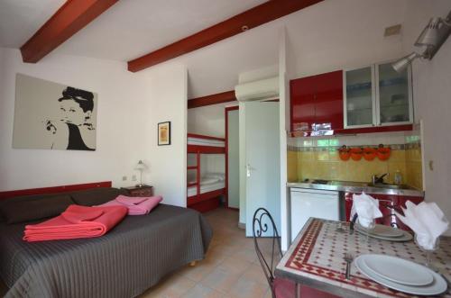 a small bedroom with a bed and a kitchen at Le Clos des Galéjades in Porquerolles
