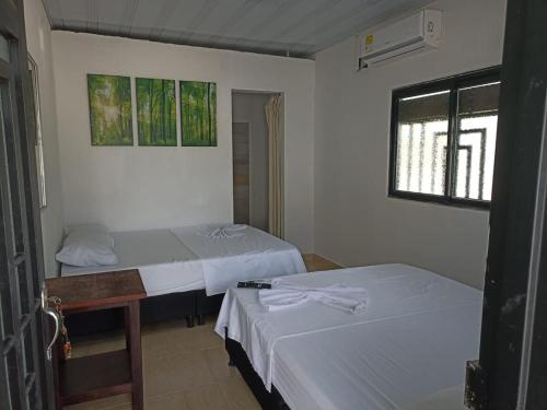 a room with two beds and a window at Alojamiento la esmeralda in Puerto Triunfo