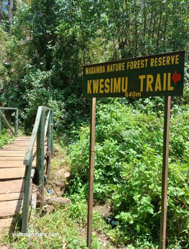 a sign for a forest reserve with a wooden bridge at Camping Magamba Forest in Lushoto