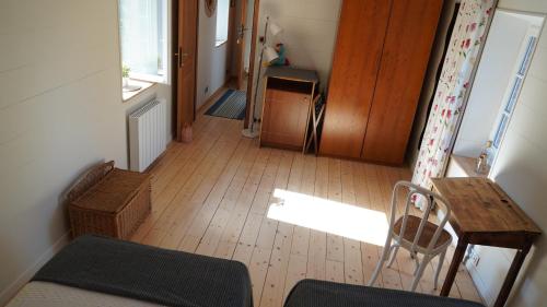 a hallway with a chair and a table and a door at Au Coq Bleu in Mareugheol