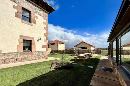 a backyard with a picnic table and a building at Las Casonas de Don Pedro in Reinosa