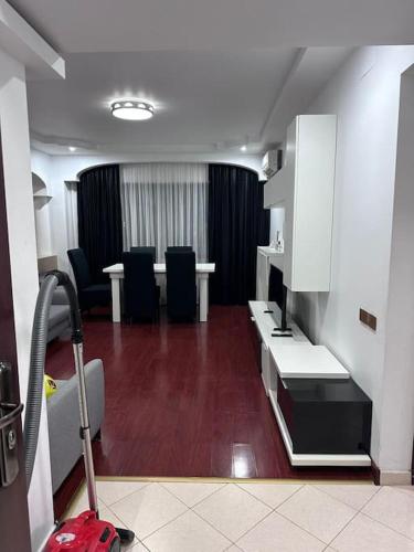 una habitación con una sala de espera con sillas negras y una maleta roja en Apartament Complex en Bucarest
