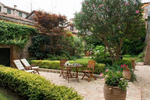 een patio met stoelen en een tafel in de tuin bij San Giacomo in Venetië