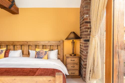 1 dormitorio con cama y mesita de noche con lámpara en West End Farm, en Great Driffield