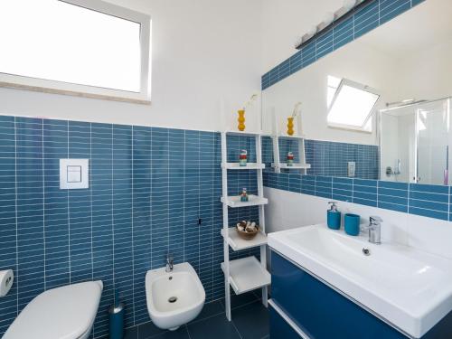 bagno piastrellato blu con servizi igienici e lavandino di Rifugio a Mare a Calabernardo