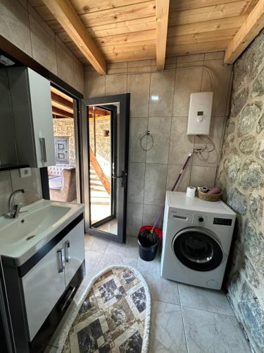a bathroom with a washing machine and a sink at Panpubungalov in Pazar