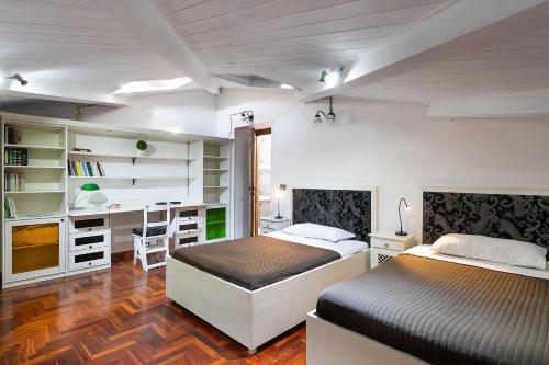 1 dormitorio con 2 camas y escritorio en Villa Carolina, en San Corrado di Fuori