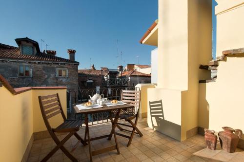 patio con mesa y sillas en el balcón en Rialto, en Venecia