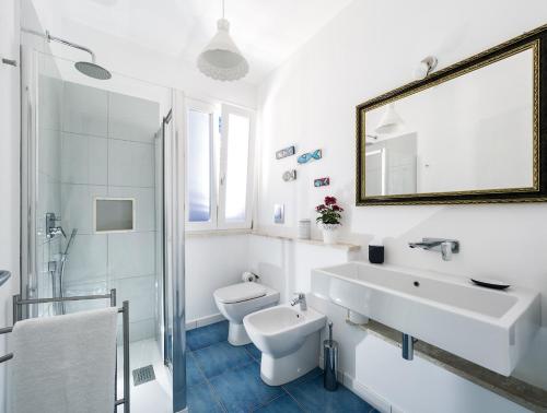 a white bathroom with a sink and a mirror at Spuma di Mare - Riccio in San Vito lo Capo