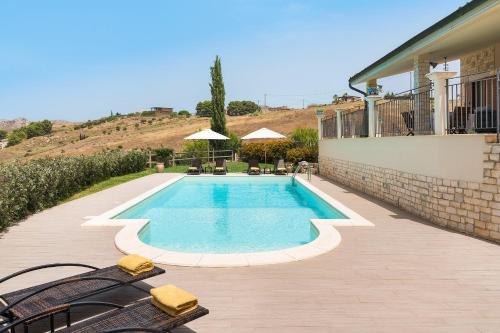 a swimming pool with two chairs next to a house at Villa Anthea in Montallegro