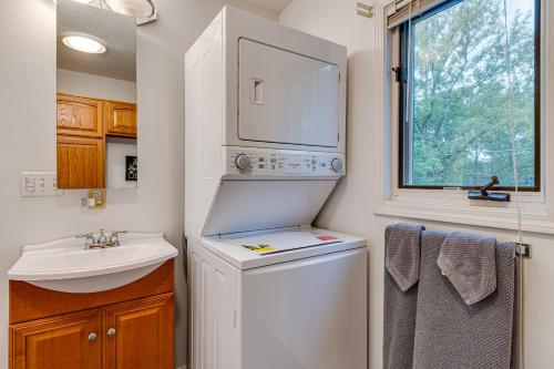 uma pequena casa de banho com uma máquina de lavar e secar roupa e um lavatório. em Riverfront Brookston Retreat with Deck and River Tubes 